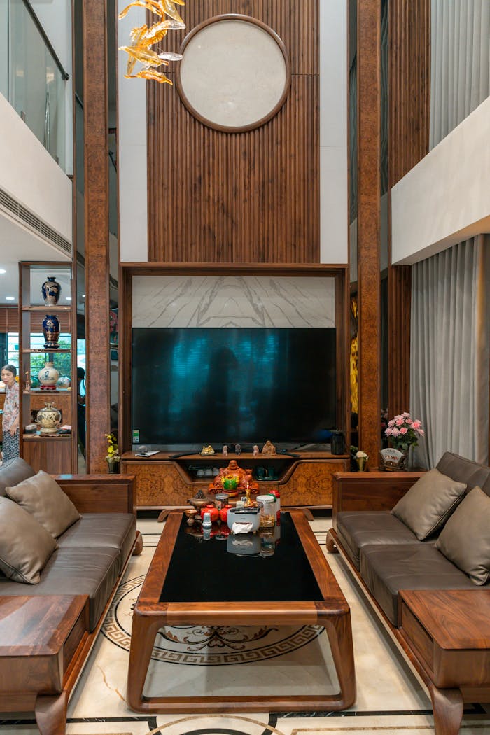 Elegant living room with wooden accents, plush sofas, and a large TV creating a cozy ambiance.